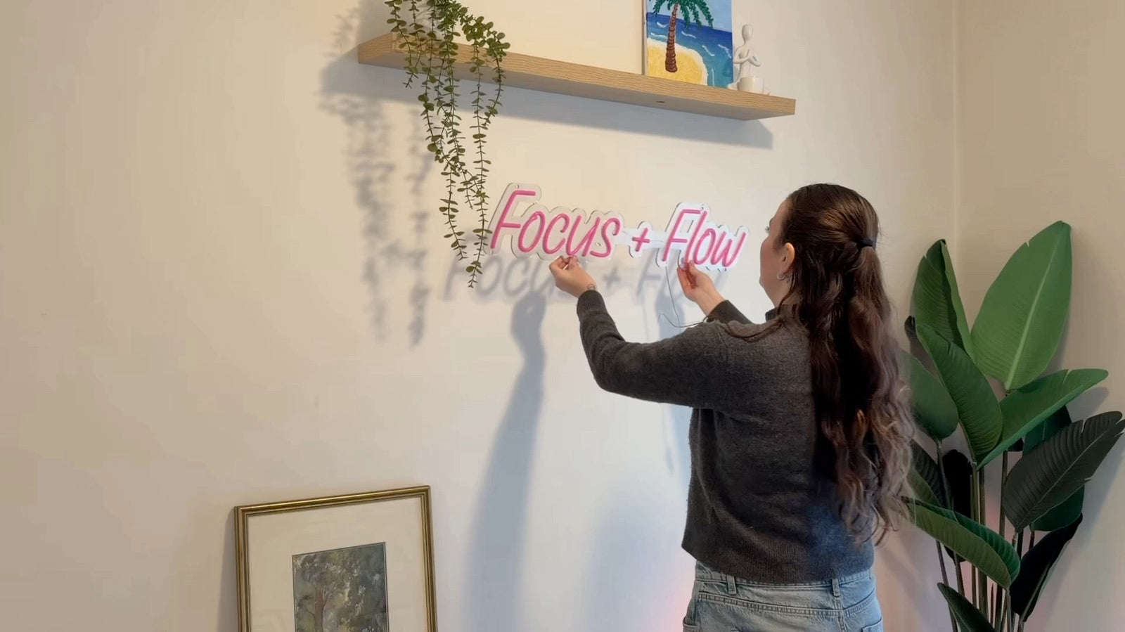 Positioning an acrylic LED neon sign on a wall before installation