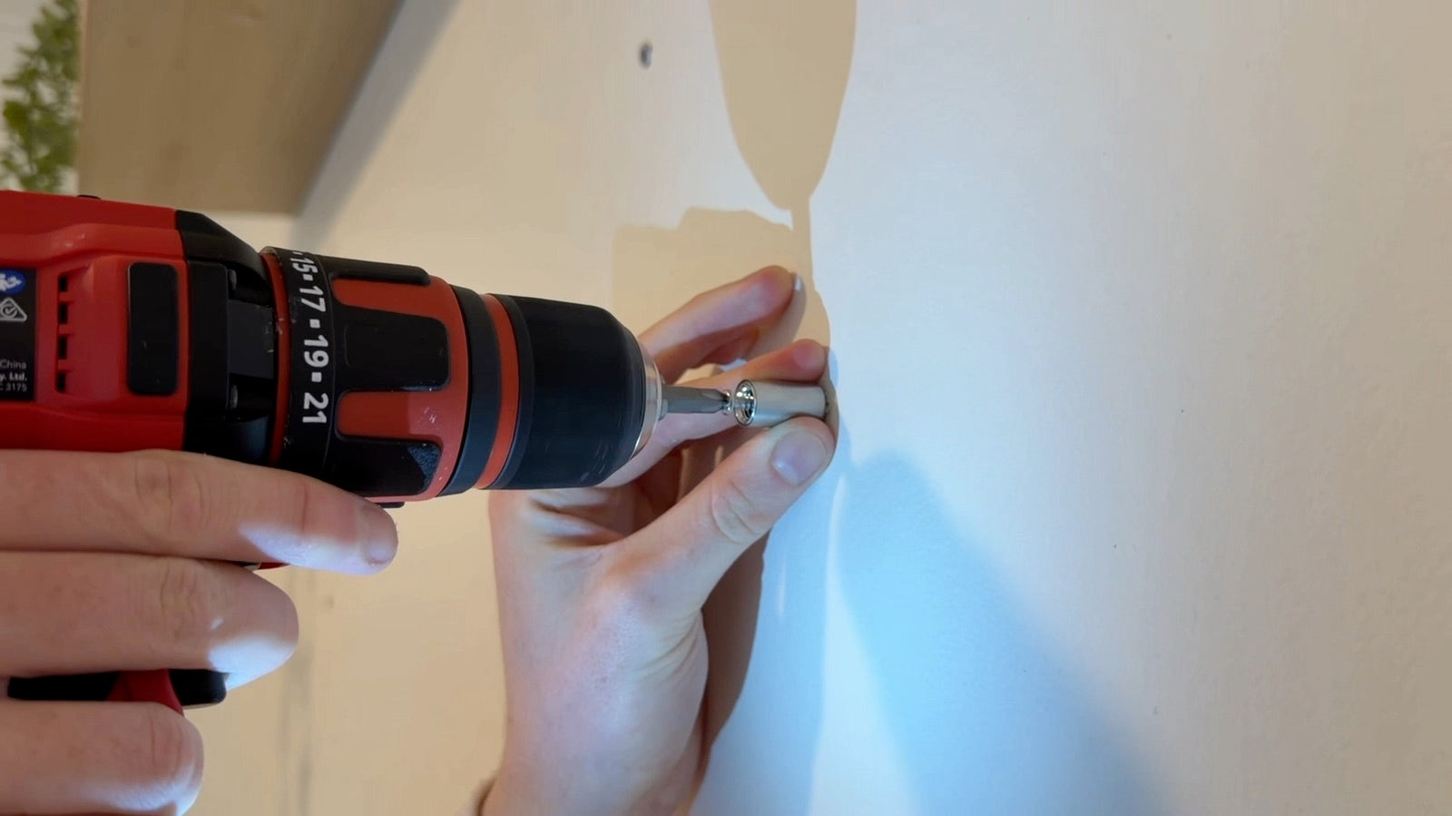 Securing a metal standoff base for a wall-mounted neon sign