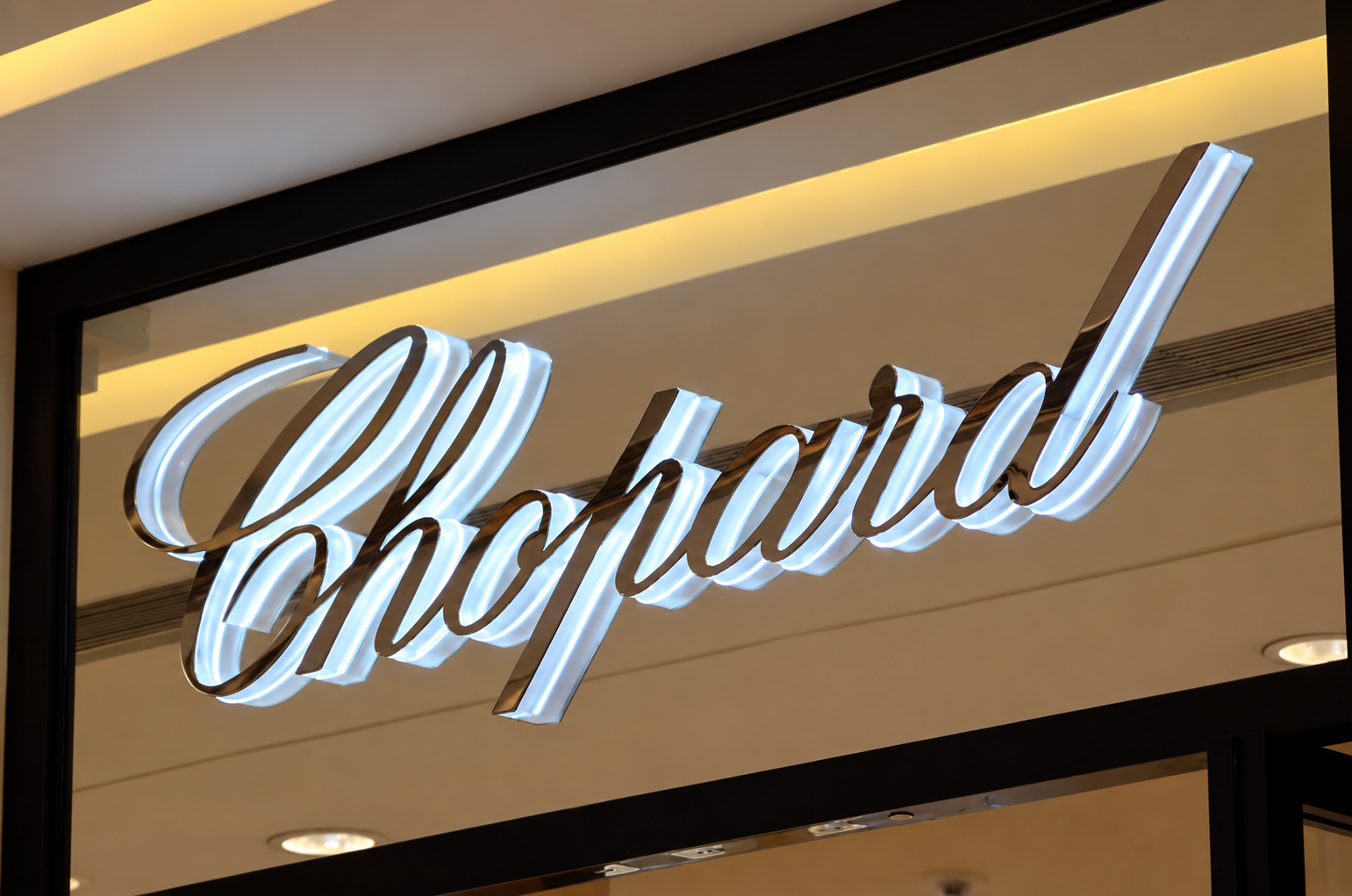 Custom side-lit business letters glowing on a modern shopfront