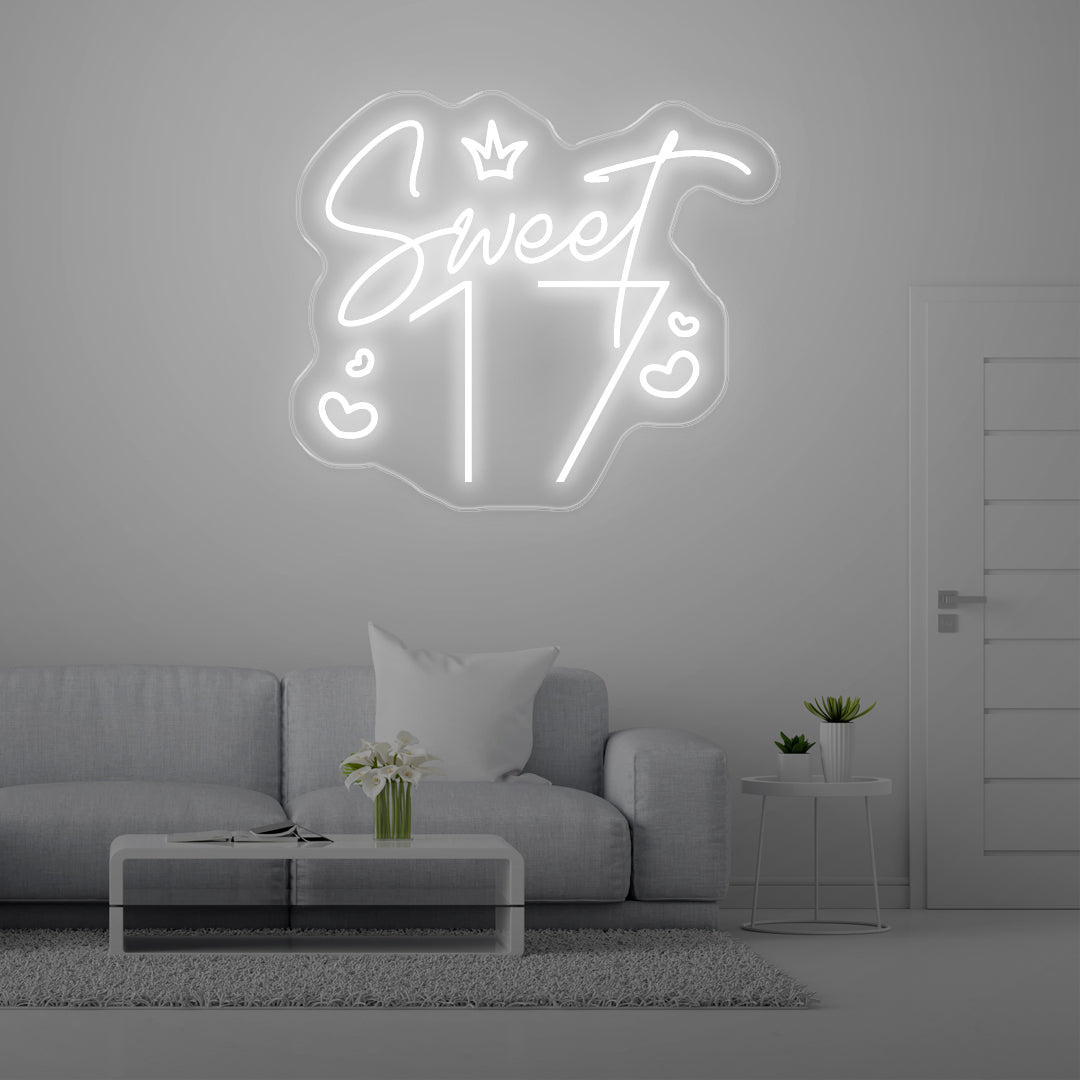 White neon "Sweet 17" sign above gray couch